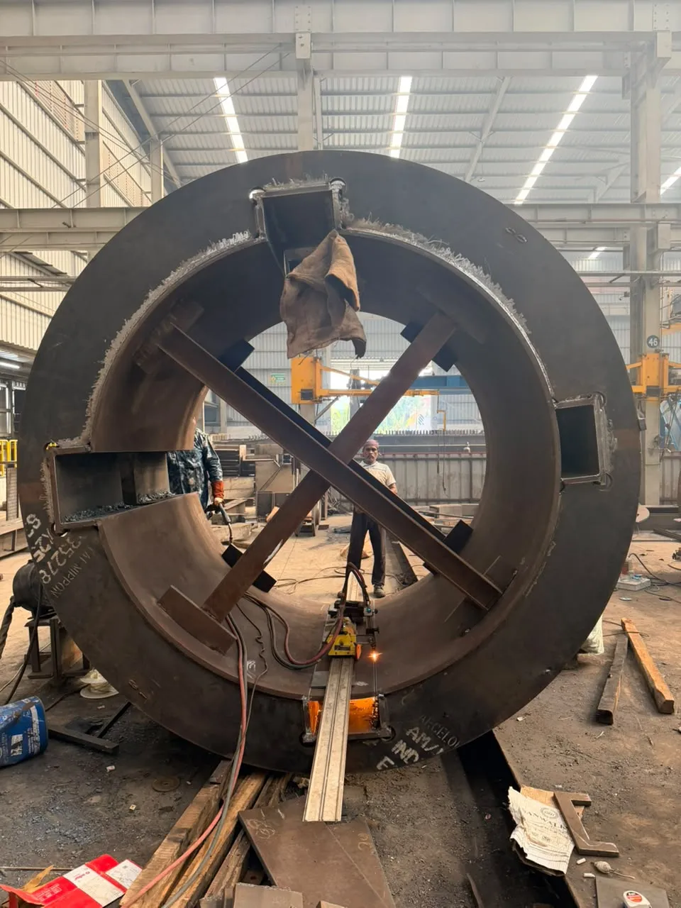 A yoke ring with pin-box openings, braced with a temporary X while it is welded