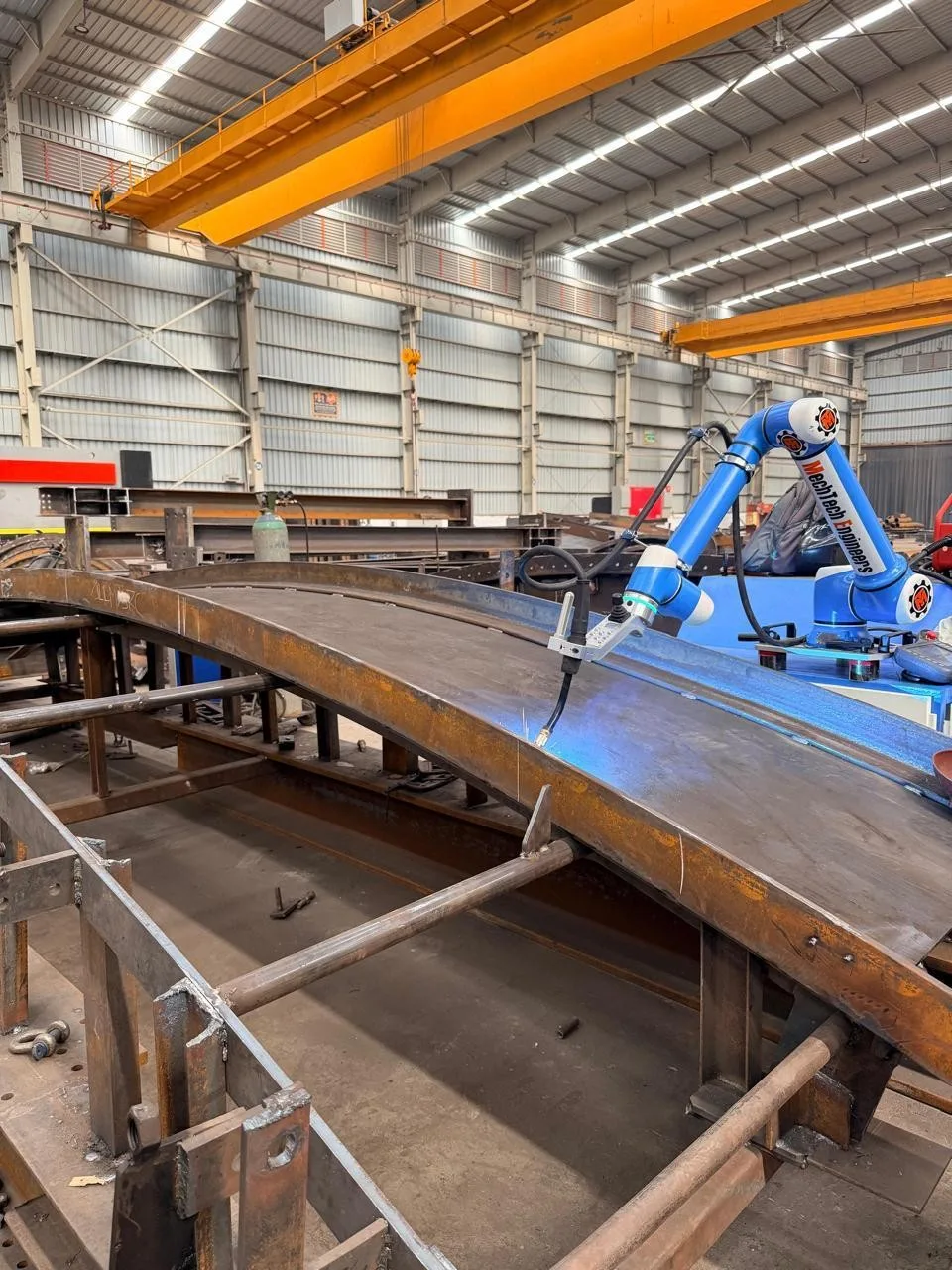A cobot welding panels clamped on fixtures